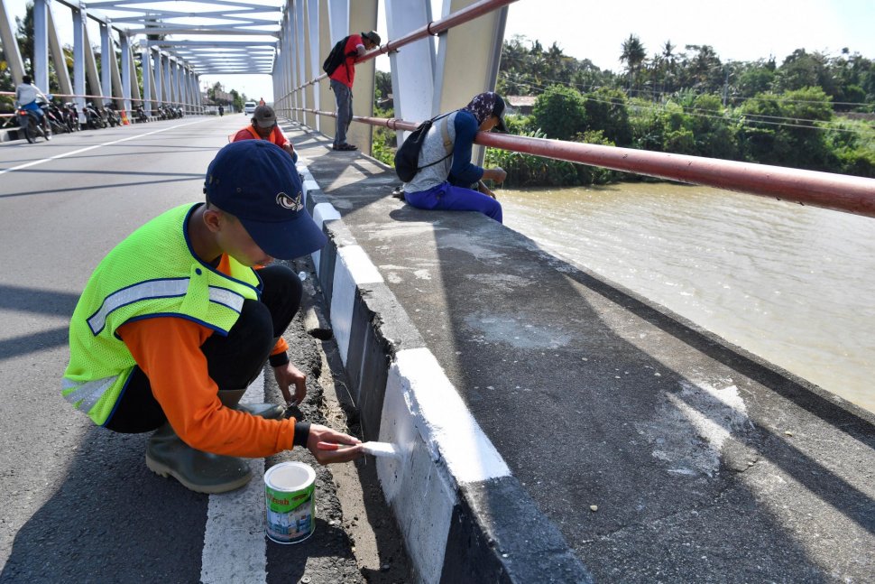 Pekerja mengecat marka jalan di Jembatan Jali Ketawang, Purworejo, Jawa Tengah, Jumat (10/5). ANTARA FOTO/Puspa Perwitasari