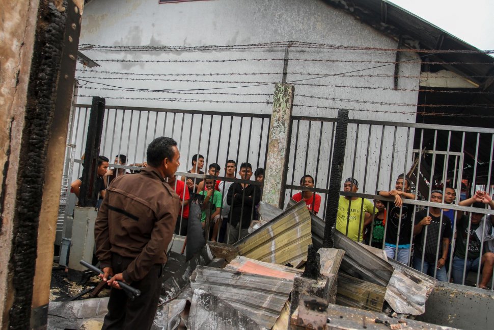 Sejumlah narapidana berada di dekat puing bangunan Rutan yang hangus terbakar pasca kerusuhan di Rutan Kelas II B Siak Sri Indrapura, Kabupaten Siak, Riau, Sabtu (11/5). ANTARA FOTO/Rony Muharrman