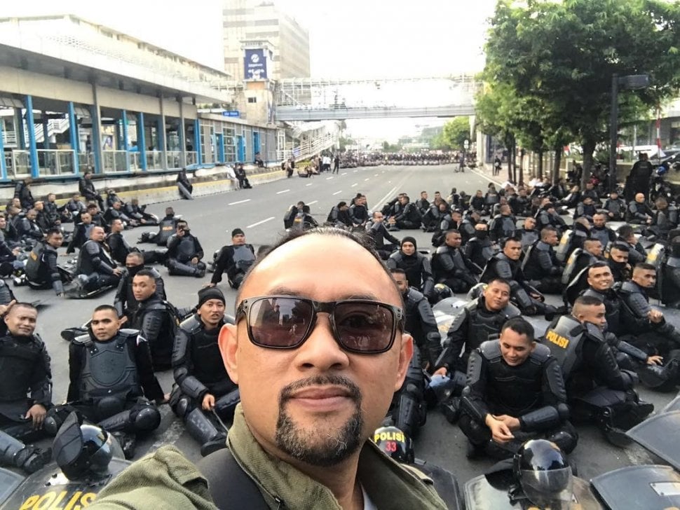 Ronald Surapradja berpose bareng aparat yang menjada demo di Bawaslu. [Instagram]