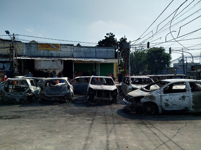 Bangkai mobil di kompleks Asrama Brimob Petamburan yang dibakar massa. (Suara.com/M Yasir)