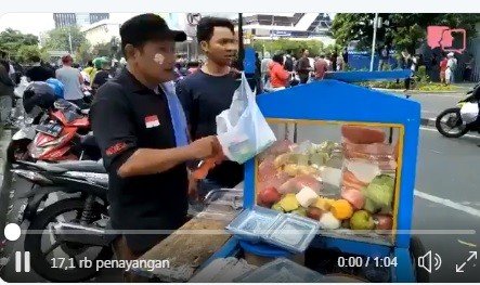 Pedagang rujak cuek berjualan di tengah demo di Bawaslu. [Twitter]