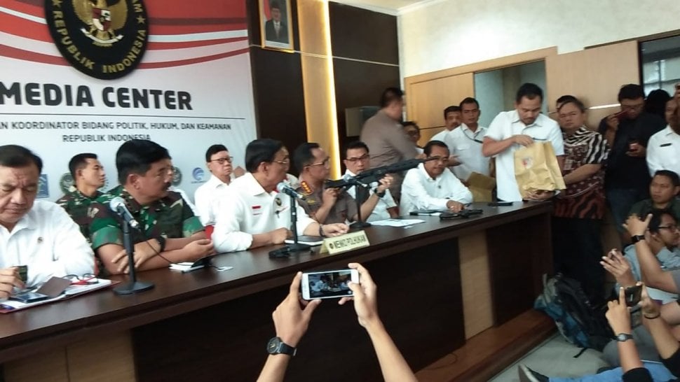 Kapolri Jenderal Polisi Tito Karnavian menunjukkan satu unit senjata serbu jenis M4, sepucuk pistol, dan satu unit revolver yang disita setelah hendak dipakai kelompok tertentu saat aksi 22 Mei, Rabu hari ini. [Suara.com/Ria Rizki Nirmala Sari]