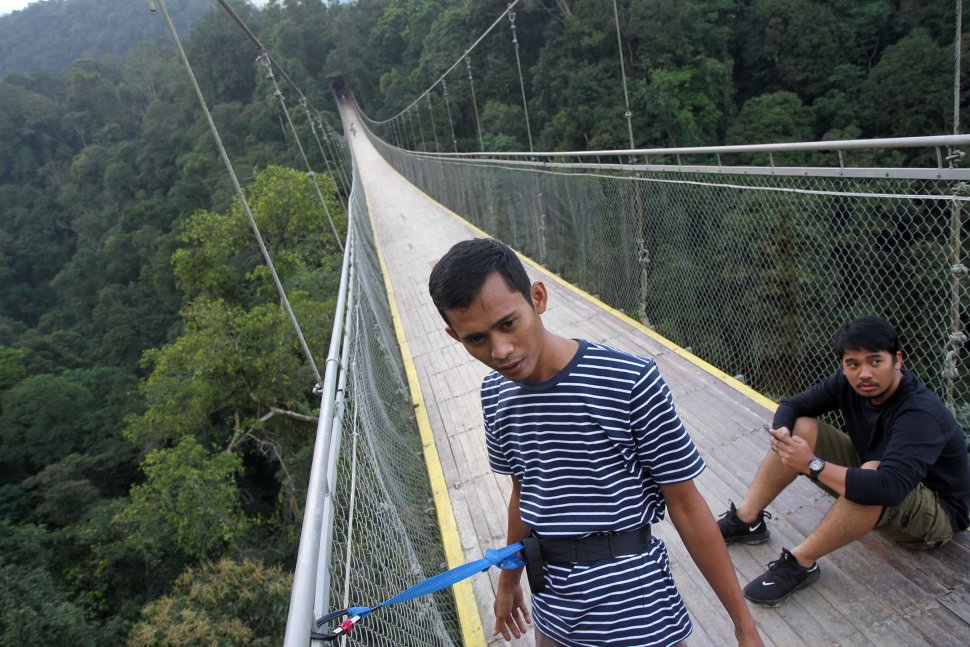 Wisatawan Jembatan Gantung Situ Gunung (Suspension Bridge Situ Gunung) di Kawasan Taman Nasioal Gunung Gede Pangrango (TNGGP), Kadudampit, Kabupaten Sukabumi, Jawa Barat, Jumat (25/5). [Suara.com/Arief Hermawan P]