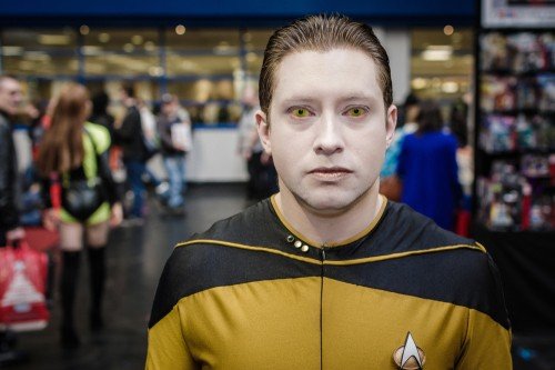 Seorang artis mengenakan seragam pasukan Starfleet dari film Star Trek. Perhatikan lencana mirip huruf V pada dada sebelah kirinya. [Shutterstock]