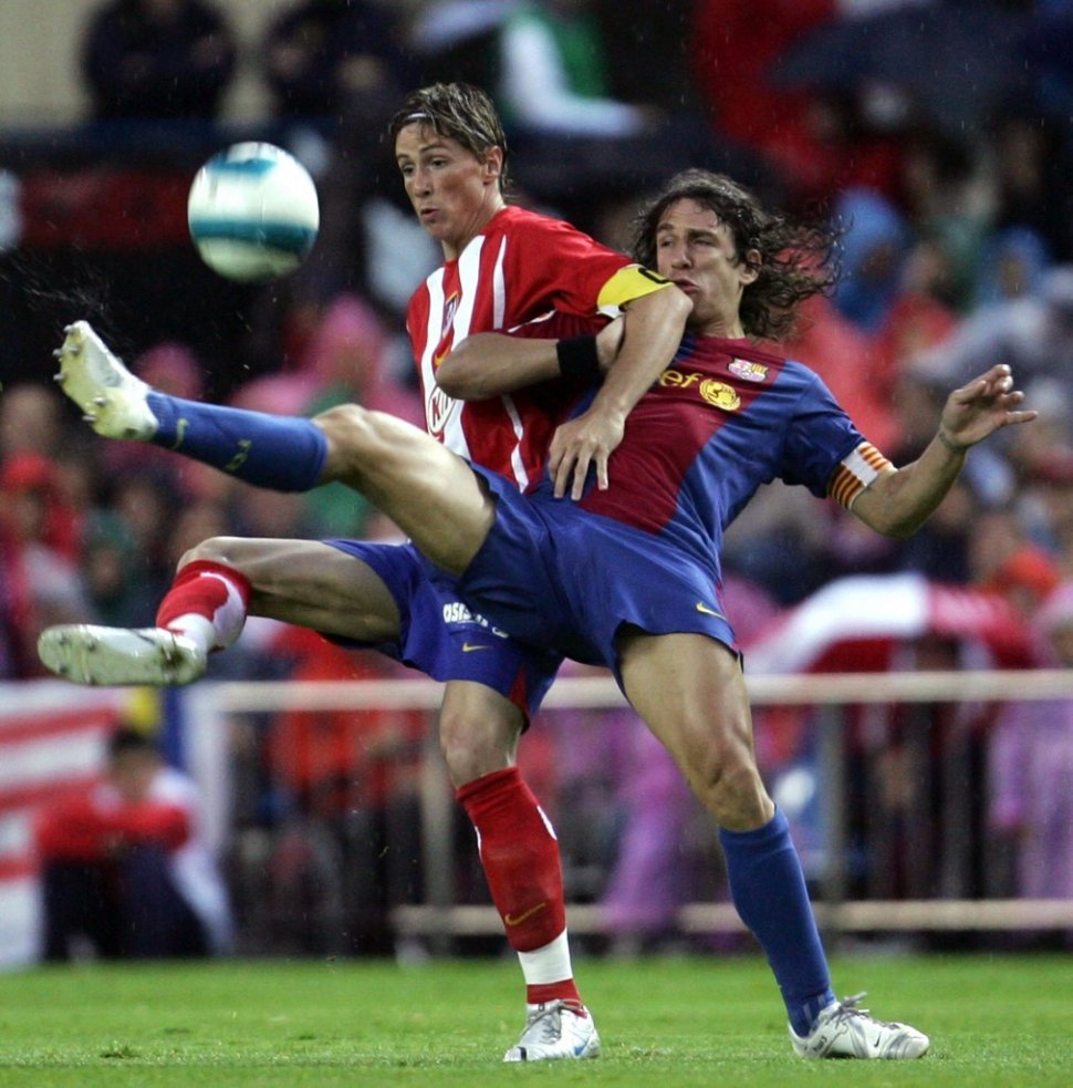 Momen ketika Fernando Torres berduel dengan Carles Puyol. (Bru Garcia/AFP).