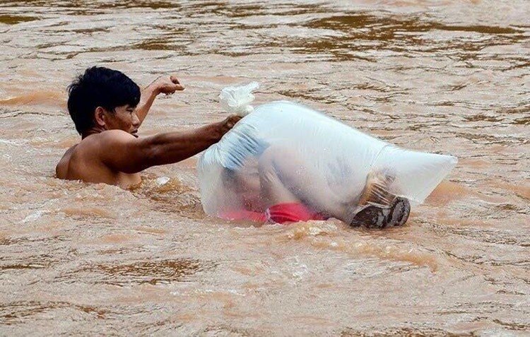 Viral! Ibu dan Ayah Masukkan Putranya ke Kantong Plastik agar Tak Basah saat seberangi sungai demi ke sekolah. [Philippine News]