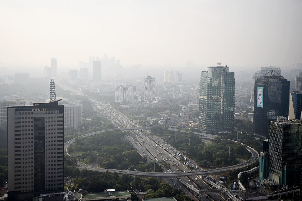 Gedung bertingkat tersamar kabut polusi udara di Jakarta, Senin (8/7). [ANTARA FOTO/M Risyal Hidayat]