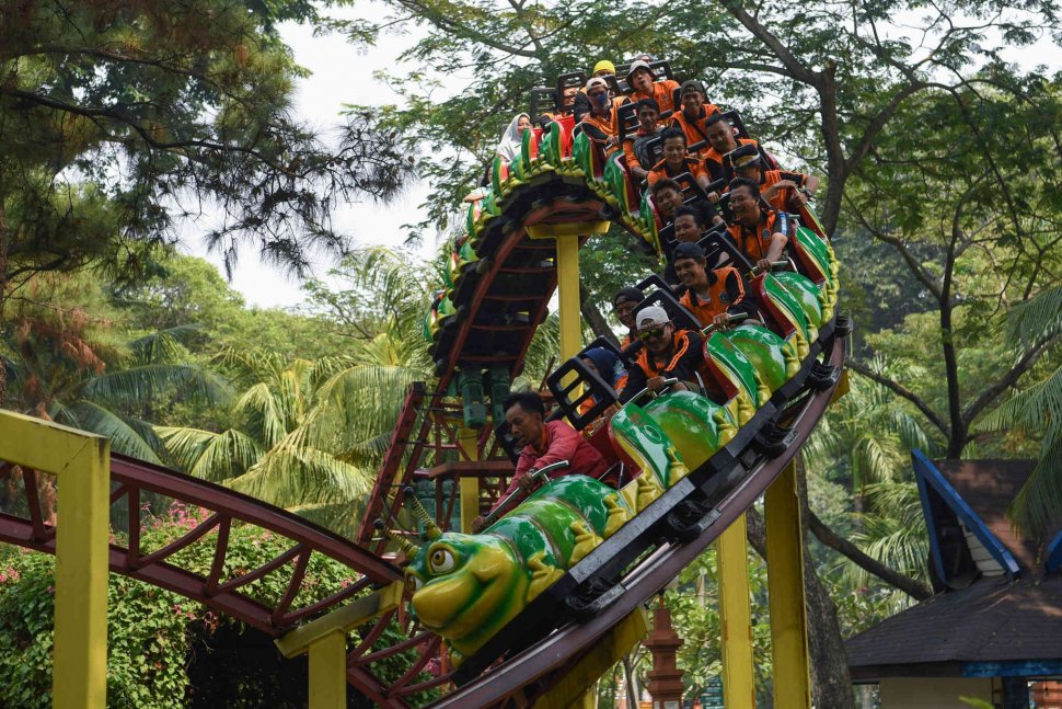 Dua petugas Penanganan Prasarana Sarana Umum (PPSU) DKI Jakarta mencoba wahana permainan saat berwisata di Dufan, Ancol, Jakarta, Senin (22/7). ANTARA FOTO/Wahyu Putro A