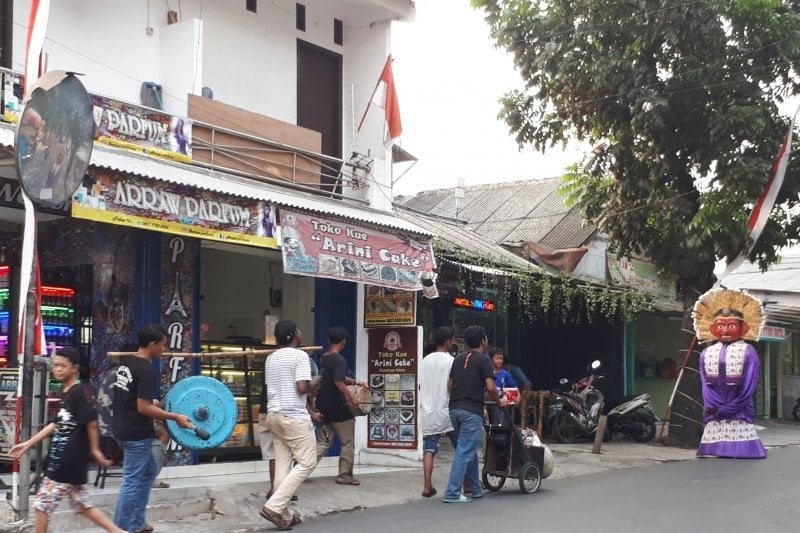 Kelompok kesenian Ondel-ondel lengkap dengan musik pengiring berkeliling masuk-keluar gang dan perumahan di kawasan Lubang Buaya, Jakarta Timur, Minggu (21/7/2019). [Adnan Nanda]