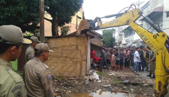 Penggusuran rumah di area Gedung WarenHuis Jalan Ahmad Yani VII, Medan, Sumatera Utara, Jumat (13/9) pekan ini berlangsung ricuh. Warga yang menolak, membalas memakai berbagai cara. [Kabarmedan]
