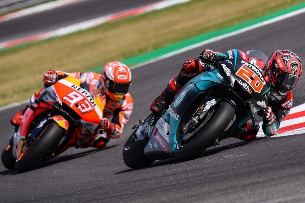 Pebalap Repsol Honda, Marc Marquez (kiri), menempel ketat pesaingnya Fabio Quartararo (Yamaha Petronas SRT) yang memimpin balapan hampir di sepanjang lomba pada MotoGP San Marino 2019 di Sirkuit Misano, Minggu (15/9). [AFP/Marco Bertorello]