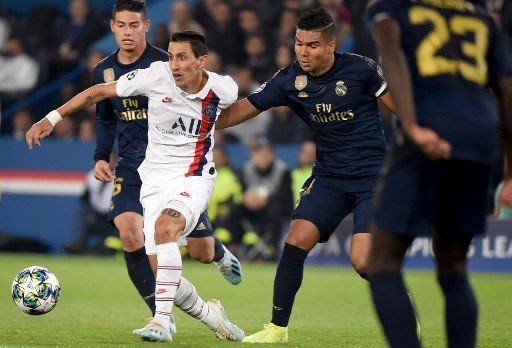 Pemain Real Madrid Casemiro (kanan) mencoba menghentikan laju winger PSG Angel Di Maria dalam pertandingan Liga Champions di Parc des Princess, Kamis (19/9/2019). [AFP]