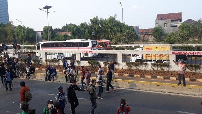 Aksi corat-coret para pendemo saat berunjuk rasa di depan gedung DPR RI. (Suara.com/Novian).