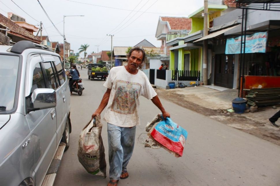 Slamet Hari Natal saat mengepul sampah. [Suara.com/Aziz Ramadani]