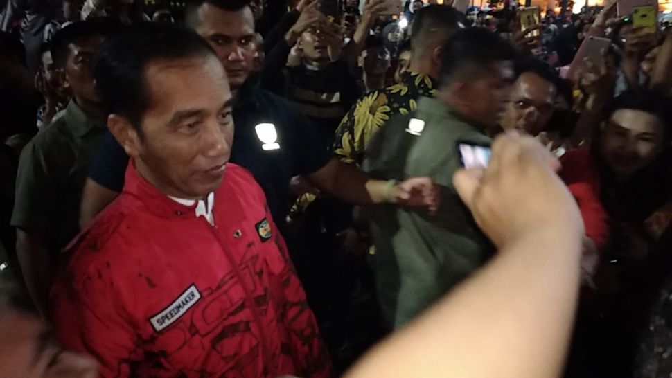 Presiden Joko Widodo (Jokowi) berswafoto bersama wisatawan saat mengunjungi kawasan Kilometer 0, Malioboro Yogyakarta, Senin (30/12/2019). (SuaraJogja.id/Baktora)
