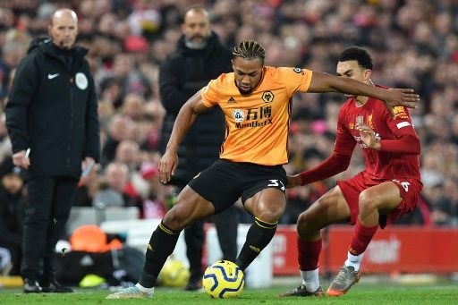 Pemain Wolverhampton Adama Traore berebut bola dengan pemain Liverpool [AFP]