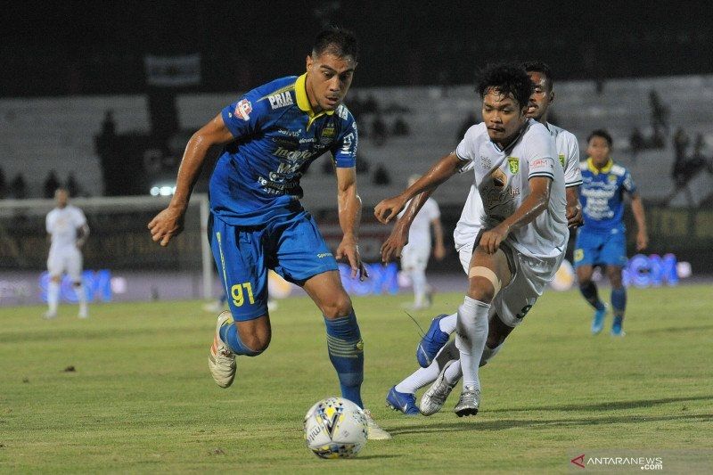 Pesepak bola Persib Bandung Omid Nazari (kiri) menggiring bola dibayangi pesepak bola Persebaya Surabaya Muhammad Hidayat dalam pertandingan sepak bola Liga 1 2019 di Stadion I Wayan Dipta, Gianyar, Bali, Jumat (18/10/2019). ANTARA FOTO/Nyoman Budhiana/wsj.