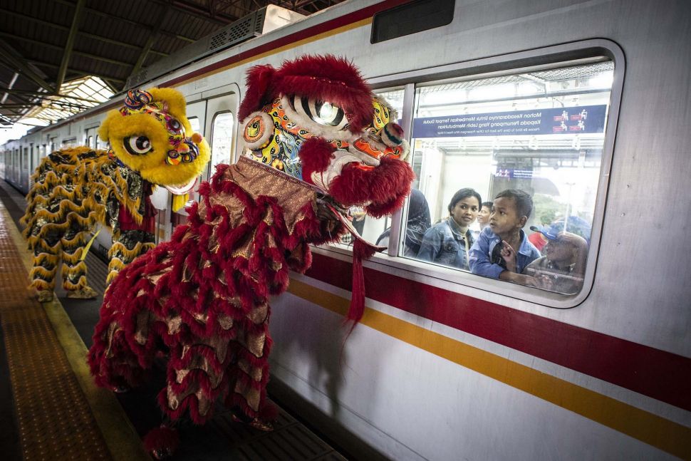 Penumpang KRL menyaksikan aksi Barongsai di peron Stasiun Gambir, Jakarta, Sabtu (25/1). [ANTARA FOTO/Aprillio Akbar]