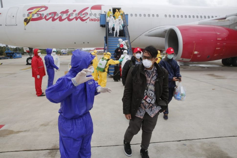 Petugas medis mengarahkan Warga Negara Indonesia (WNI) dari Wuhan, China yang telah disemprot cairan disinfektan setibanya di Pangkalan Udara Raden Sajad, Natuna, Kepulauan Riau, Minggu (2/2). [ANTARA FOTO/Kementerian Luar Negeri RI]