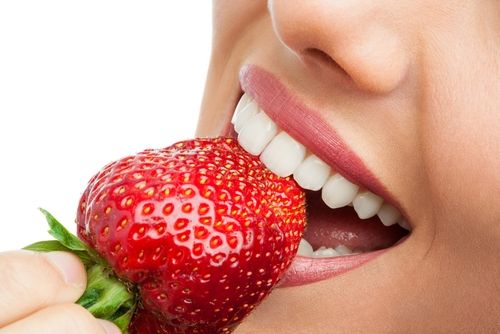 Gigi putih dengan stroberi. (Shutterstock)