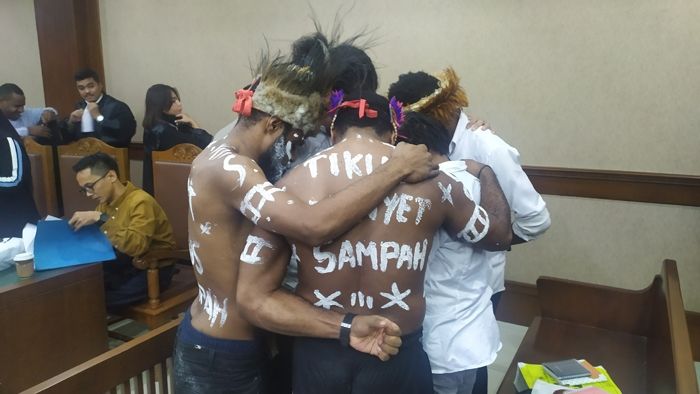 Dua orang tahanan politik Papua, Dano Anes Tabuni dan Ambrosius Mulait membubuhkan tulisan “Sampah” pada tubuh mereka, saat mengikuti sidang pemeriksaan saksi di Pengadilan Negeri Jakarta Pusat, Senin (17/2/2020) sore. [Suara.com/Stephanus Aranditio]