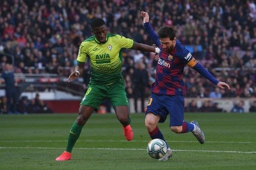 Pemain Barcelona Lionel Messi berebut bola dengan pemain Eibar dalam pertandingan La Liga yang berlangsung di Camp Nou, Sabtu (22/2/2020). [AFP]