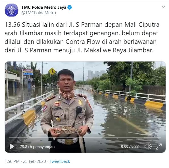AKBP Dermawan Karosekali melaporkan situasi banjir di Jakarta sambil membawa ular besar.