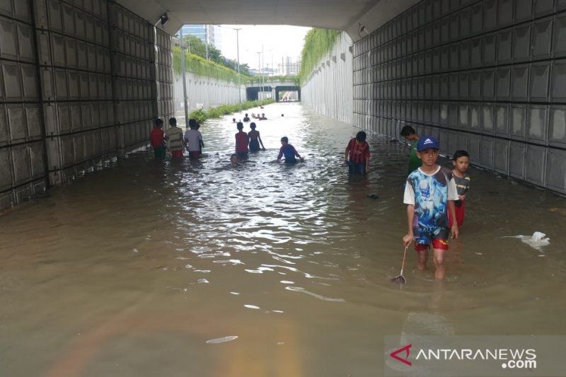 Suasana anak bermain di area banjir di Underpass Angkasa, Kemayoran, Jakarta, Selasa (25/2/2020). [Antara/Anom Prihantoro]