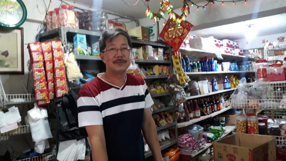 Erwin, pemilik Toko Erwin, yang menjual sembilan bahan kebutuhan pokok di Jalan K Teluk Gong, RT6/RW9 Penjaringan, Jakarta Utara, sempat viral karena tak mau melayani konsumen yang mau memborong dagangannya. [Suara.com/Novian Ardiansyah]