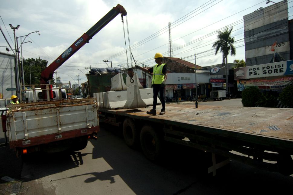 Pekerja melakukan proses penurunan beton movable concrete barrier (MBC) saat persiapan penutupan jalan di jalur Pantura Gajah Mada, Tegal, Jawa Tengah, Sabtu (28/3). [ANTARA FOTO/Oky Lukmansyah] 