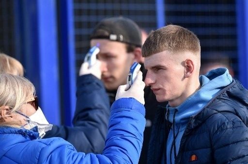 Suporter di Liga Belarusia mendapat pemeriksaan suhu tubuh sebelum memasuki stadion. (Sergei Gapon/AFP).