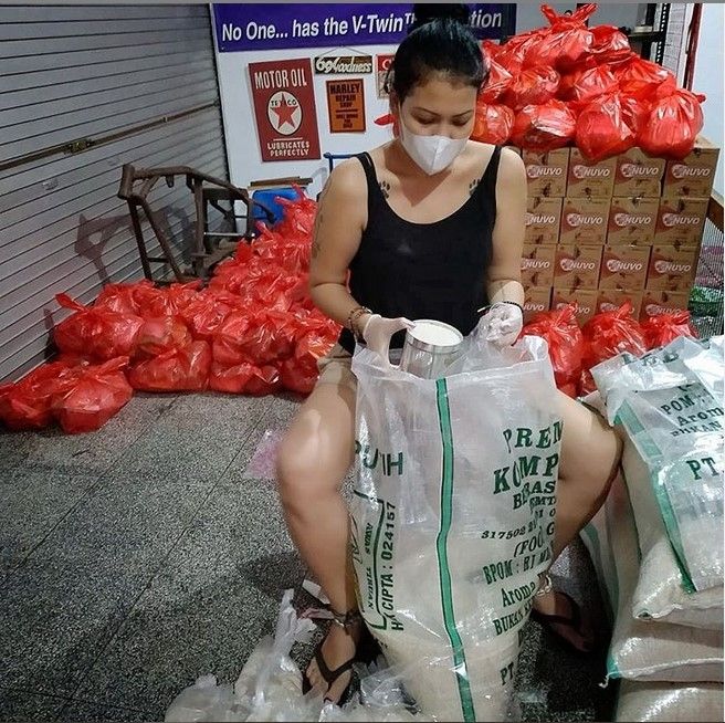 Melanie Subono menakar beras, untuk kemudian diberikan ke masyarakat. [Instagram]