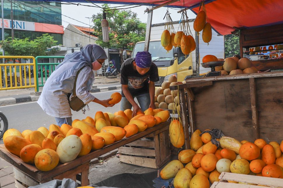 Pembeli memilih buah Timun Suri di Pasar Palmerah, Jakarta Pusat, Sabtu (25/4). [Suara.com/Alfian Winanto]