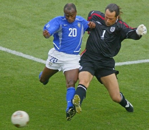 Pemain timnas Brasil Edilson berebut bola dengan penjaga gawang timnas Inggris David Seaman di pertandingan Piala Dunia 2002. [AFP]