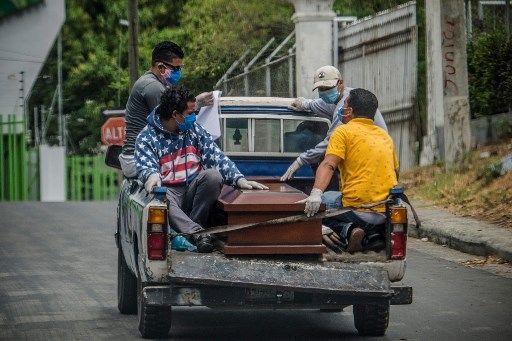 Jenazah pasien corona di bawa ke pemakaman. [AFP]