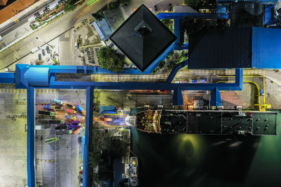 Foto aerial kendaraan logistik tujuan Sumatera antre memasuki kapal di Pelabuhan Merak Banten, Kamis (21/5) malam. [ANTARA FOTO/Galih Pradipta]