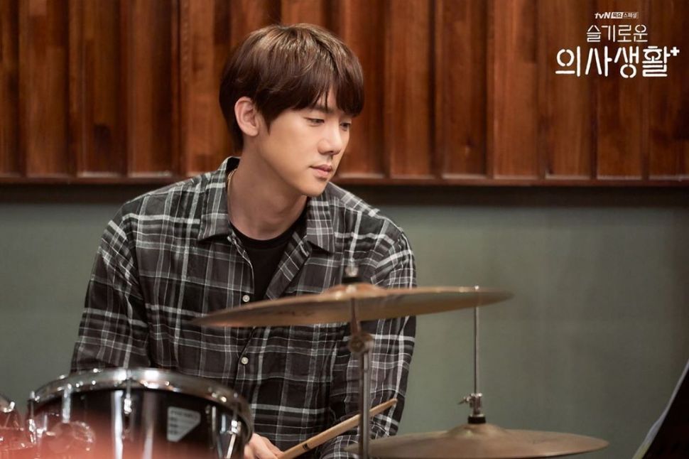 Aktor Yoo Yeon Seok berperan sebagai dokter sekaligus drummer dalam serial Hospital Playlist. (Instagram/@hospitalplaylist_official)