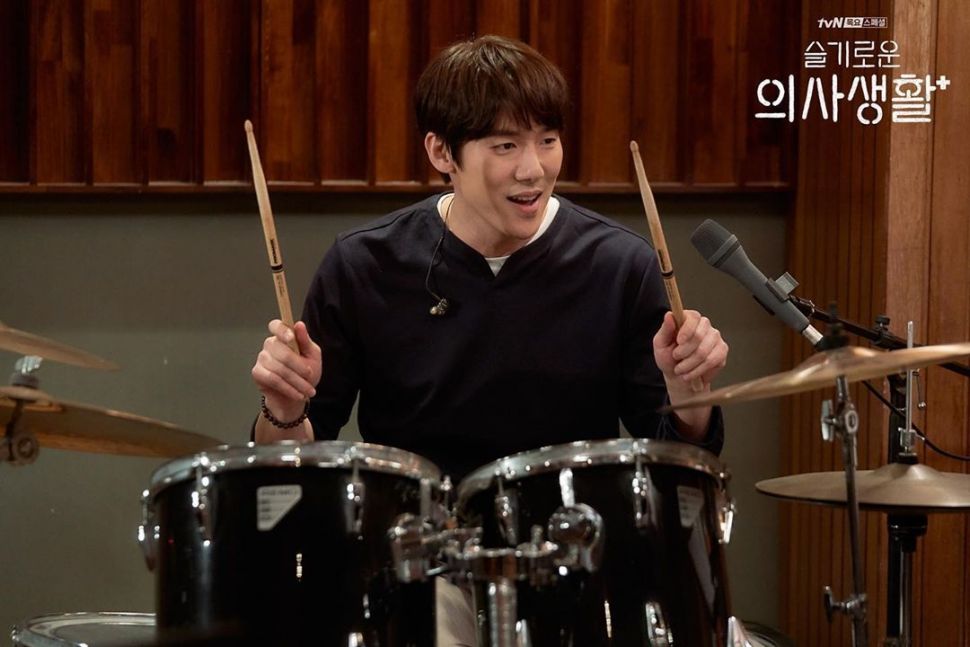 Aktor Yoo Yeon Seok berperan sebagai dokter sekaligus drummer dalam serial Hospital Playlist. (Instagram/@hospitalplaylist_official)