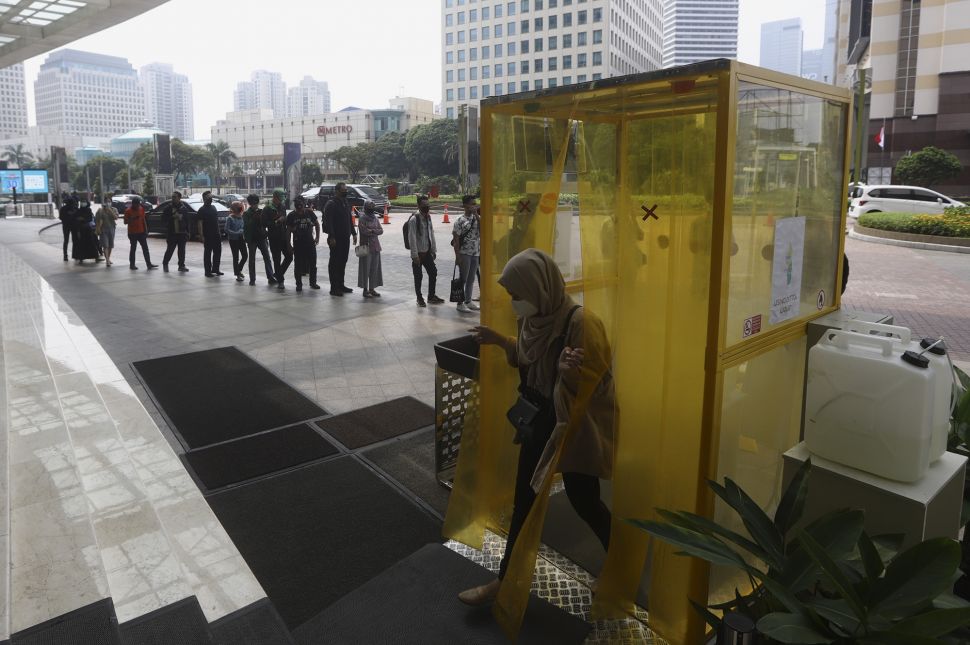 Pengunjung keluar dari bilik disinfektan sebelum memasuki Mal Senayan City, Jakarta, Selasa (9/6). [Suara.com/Angga Budhiyanto]