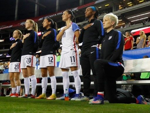 Pemain timnas putri AS, Megan Rapinoe, berlutut ketika lagu kebangsaan dinyanyikan. Hal itu dilakukan Rapinoe sebagai bentuk protes akan aksi rasisme yang terjadi pada tahun 2016 di AS. [AFP]