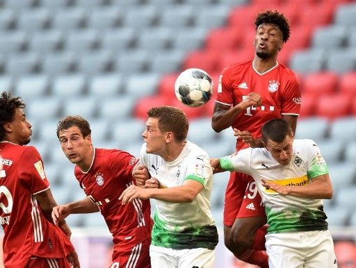 Pemain Bayern Munich dan pemain Borussia Monchengladbach berebut bola dalam pertandingan Bundesliga di Allianz Arena, Sabtu (13/6/2020). [AFP]