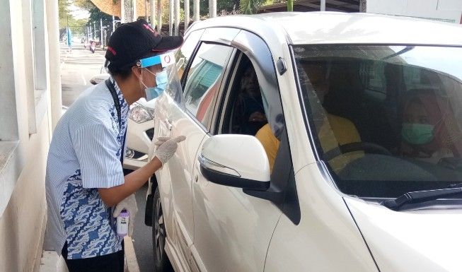 Petugas pintu masuk tampak tengah berbicara dengan pengunjung TMII, Sabtu (20/6/2020). [Suara.com/Adie Prasetyo Nugraha]