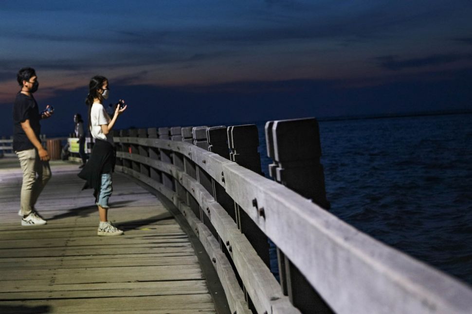 Pengunjung berswafoto di Pantai Karnaval Ancol, Jakarta Utara, Sabtu (20/6). [Suara.com/Alfian Winanto]