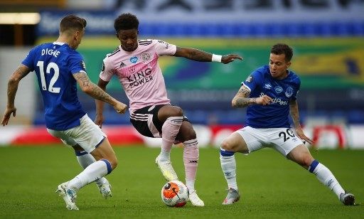 Pemain Leicester City Demarai Gray mencoba melewati dua pemain Everton dalam pertandingan Liga Premier Inggris di Goodison Park, Kamis (2/7/2020). [AFP]