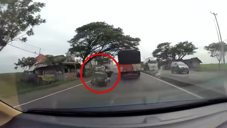 Pengendara Yamaha Nmax jatuh usai terkena lubang. (Facebook/Dash Cam Owners Indonesia)