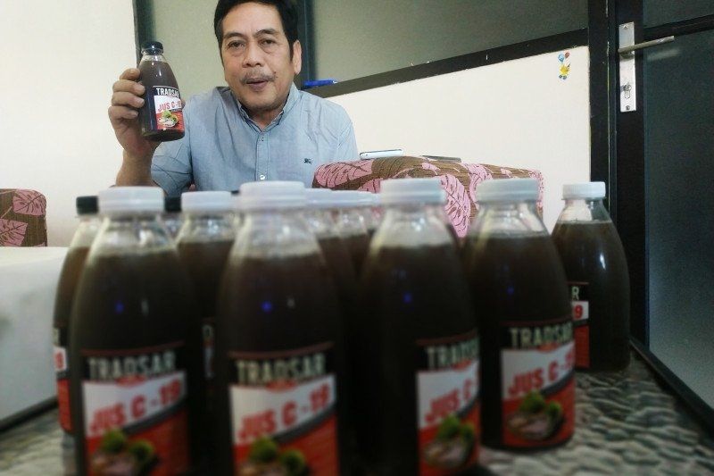 Pembuat minuman herbal sari pati buah mengkudu, Trasdar C-19, Iwan Paturusi, menunjukkan produk yang siap didistribusikan bagi pasien COVID-19 di rumah produksinya, jalan Melati, Kota Makassar, Sulawesi Selatan. ANTARA/Darwin Fatir.