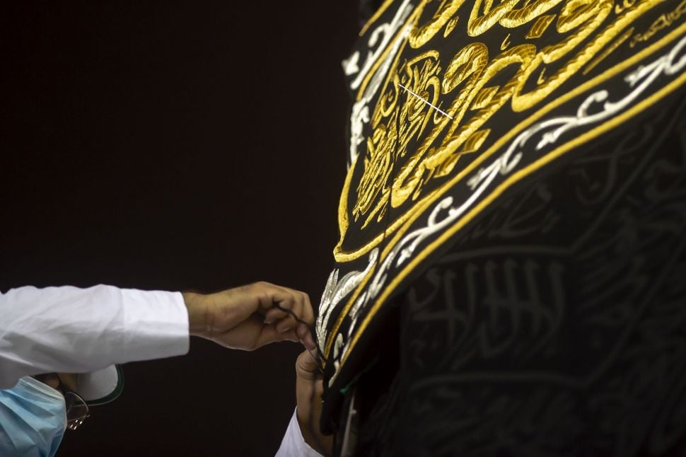 Pekerja memasang Kiswah Ka'bah yang baru yang terbuat dari kain sutra hitam dan benang emas serta disulam dengan ayat-ayat suci Alquran, Mekah, Arab Saudi, Rabu (29/7). [Foto/AFP]