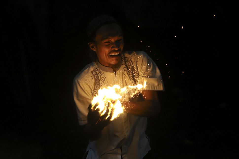 Warga bermain bola api di Kawasan Rempoa, Tangerang Selatan, Rabu (19/8/2020). [Suara.com/Angga Budhiyanto]