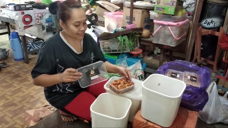 Seorang warga yang juga pedagang di Pasar Kali Online menata makanan berupa kering tempe dan kentang goreng dalam sebuah wadah di Kampung Ledok Tukangan, Tegalpanggung, Danurejan, Kota Yogyakarta, Rabu (2/9/2020). [Muhammad Ilham Baktora / SuaraJogja.id]