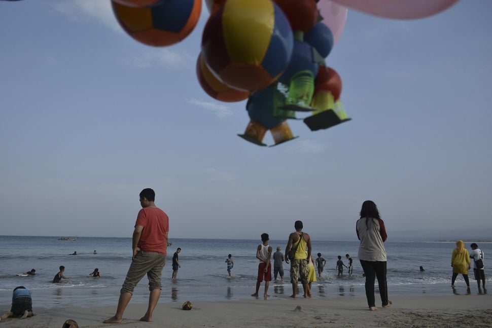 Wisatawan mengunjungi kawasan wisata Pantai Santolo, Pameungpeuk, Kabupaten Garut, Jawa Barat, Minggu (20/9/2020). [ANTARA FOTO/Candra Yanuarsyah]